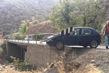 Kayganlaşan yolda kaza geçiren otomobil köprüde asılı kaldı